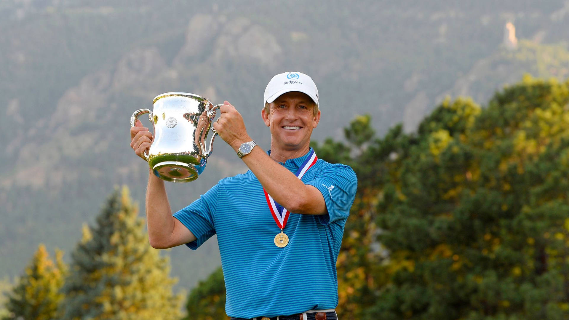 David Toms Celebrating His Victory With A Medal And Trophy. Background