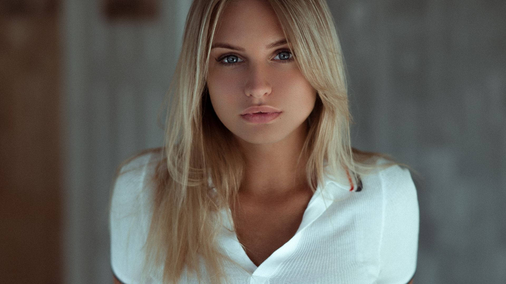 Dazzling Blonde Woman Elegantly Dressed In A White Shirt Background