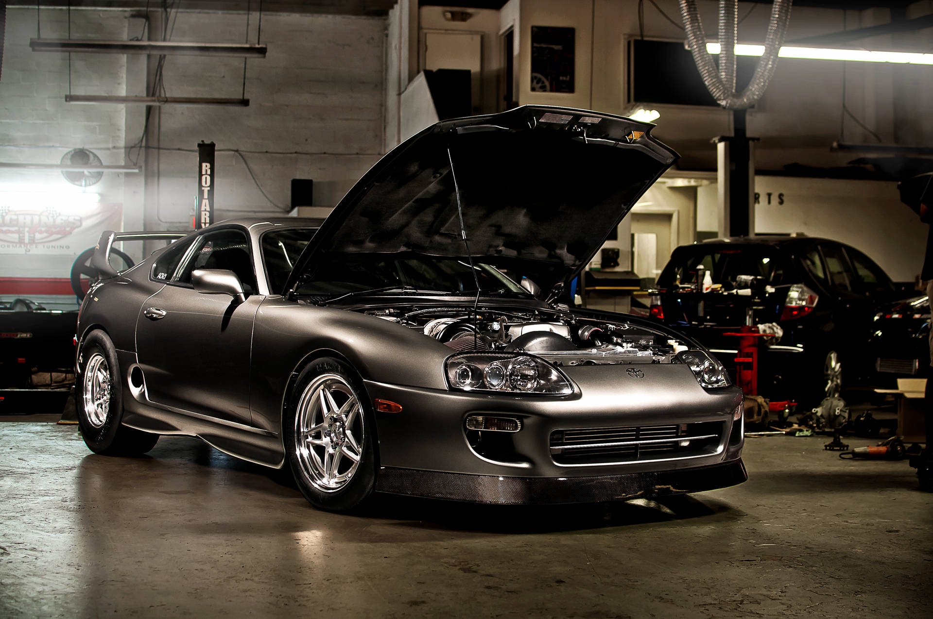 Dazzling Night View Of 4k Supra Car Against Cityscape Backdrop Background