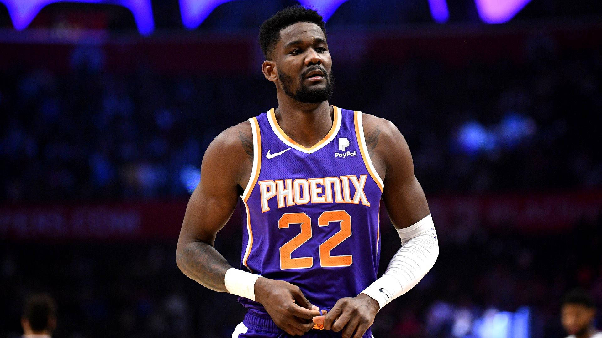 Deandre Ayton Confidently In Action On The Basketball Court Background