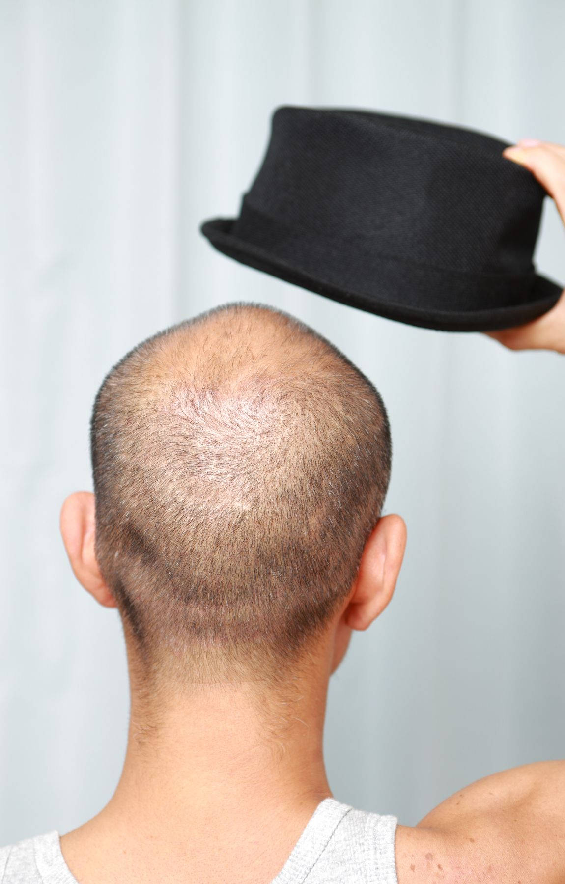 Debonair Bald Gent Holding Black Hat Background