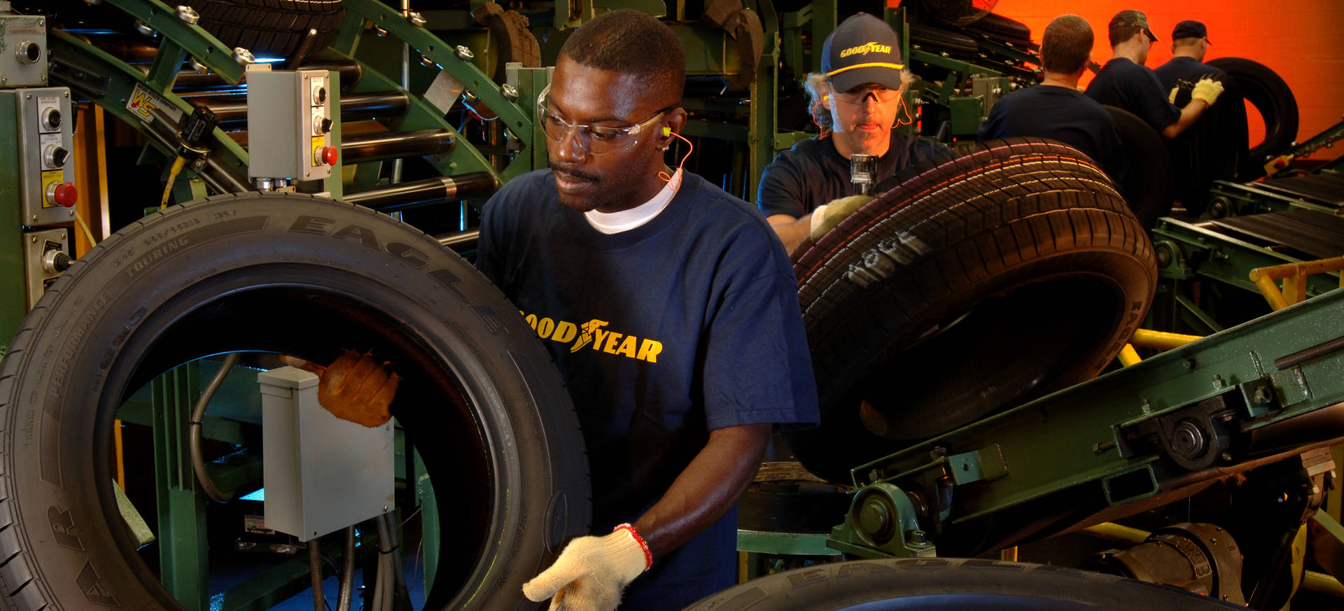 Dedicated Goodyear Workers On Assembly Line Background