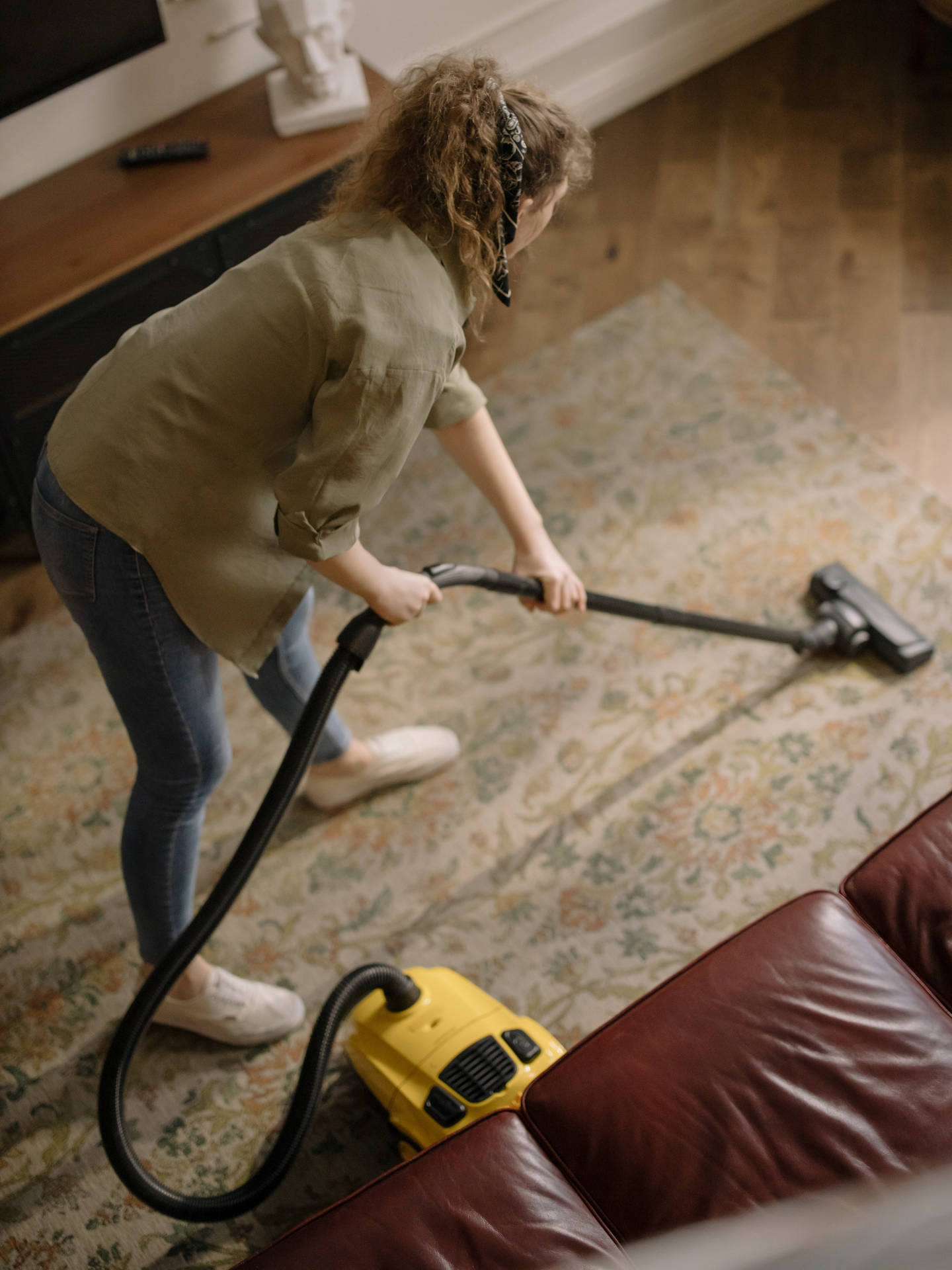 Dedicated Housekeeper Cleaning A Floor With A Vacuum Cleaner