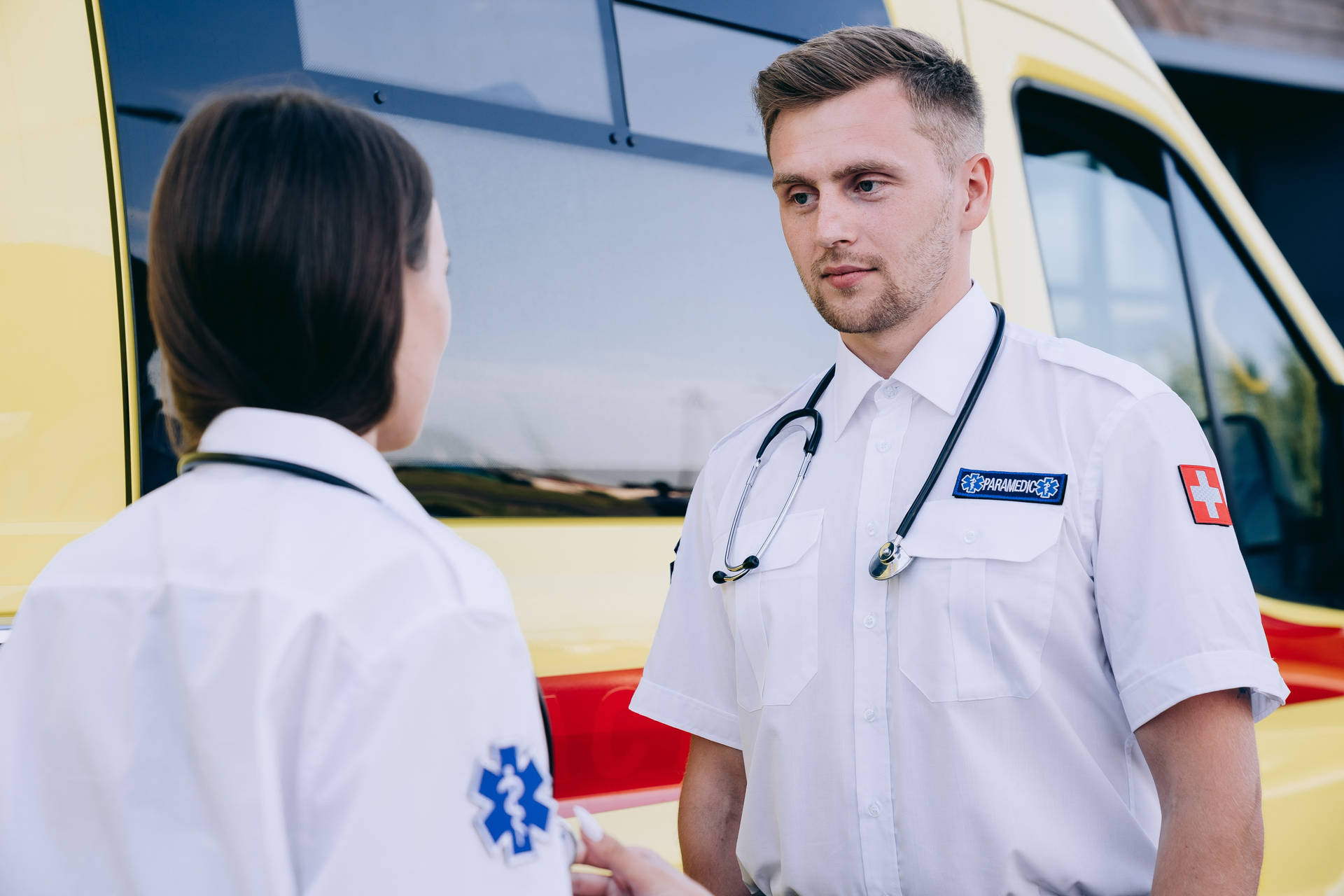 Dedicated Paramedic Gazing Into The Distance Background