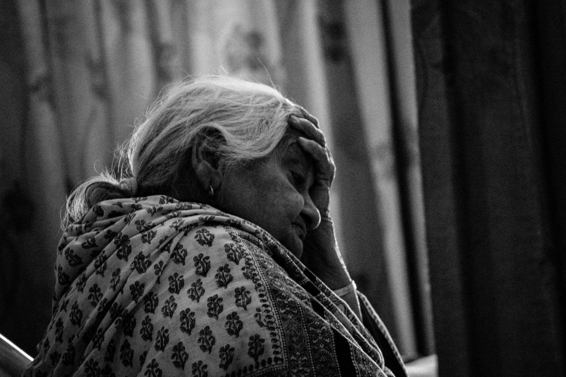 Deep In Thought - A Pensive Old Woman Background