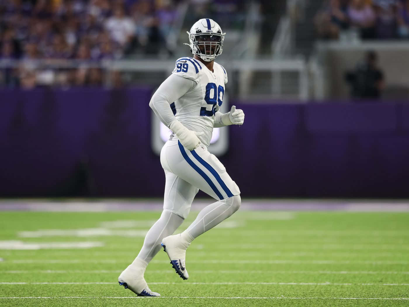 Deforest Buckner Running On Football Field Background