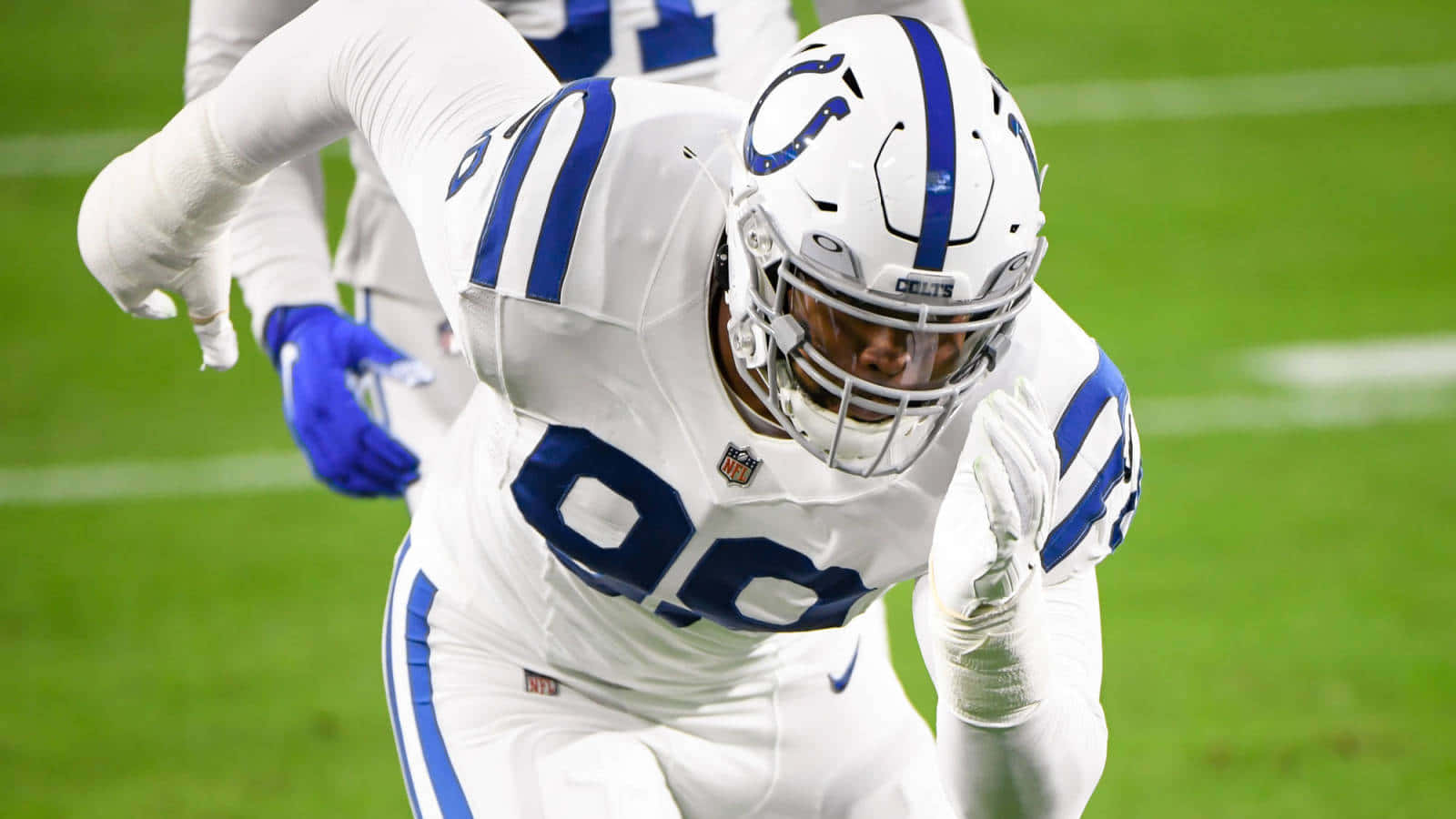 Deforest Buckner Running On The Football Field Background