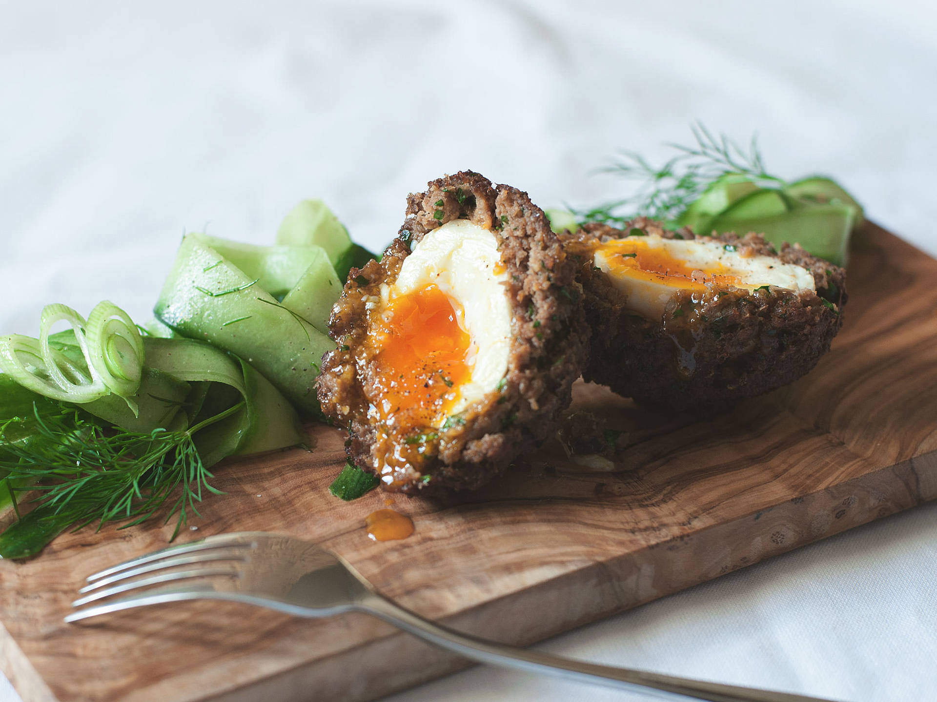 Delectable British Scotch Eggs With Finely Sliced Zucchini Background