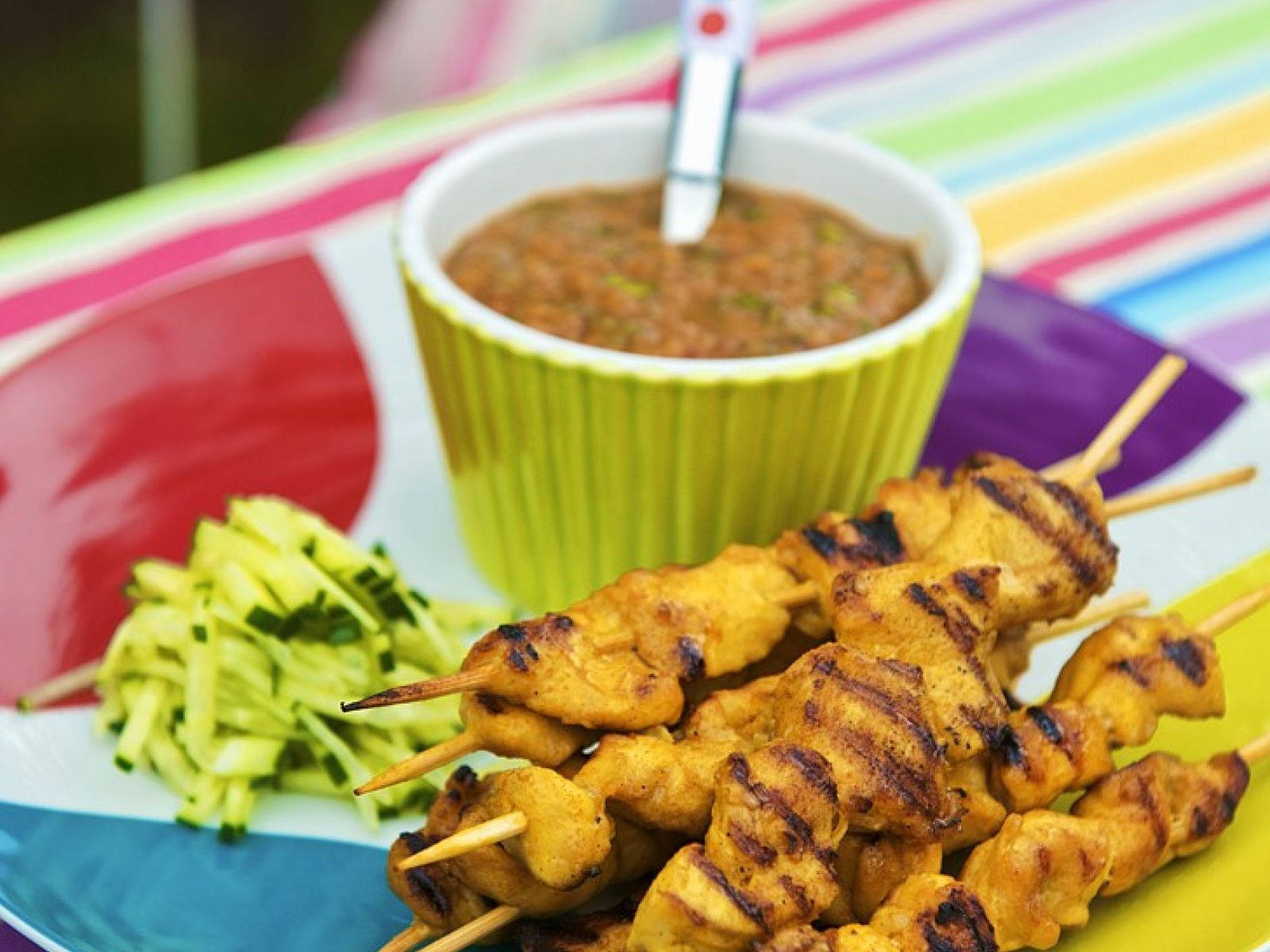 Delectable Chicken Satay Skewers With Peanut Sauce And Sliced Pickles Background