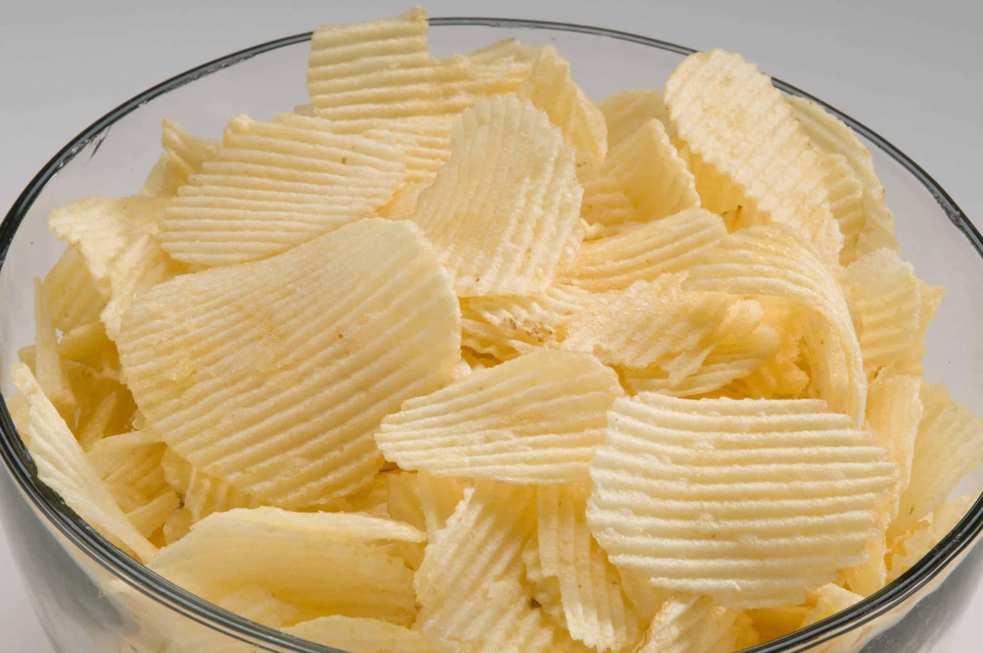 Delectable, Crunchy Potato Chips In A Glass Bowl Background