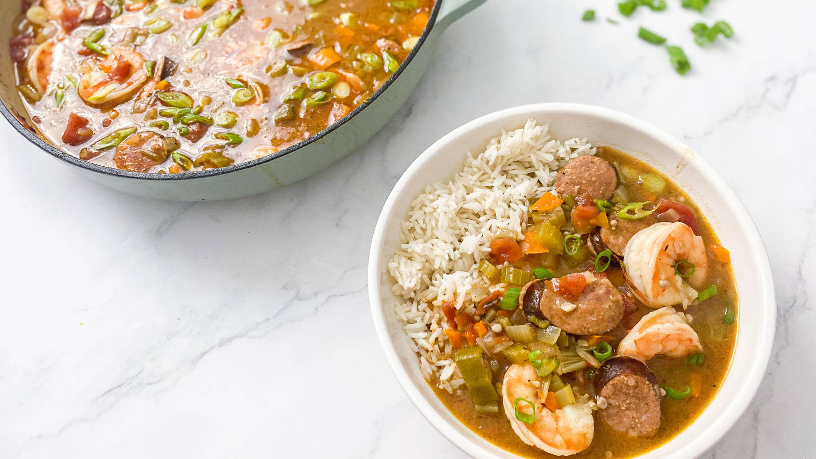 Delectable Gumbo In Pan And Plate With Rice On Marble Surface Background