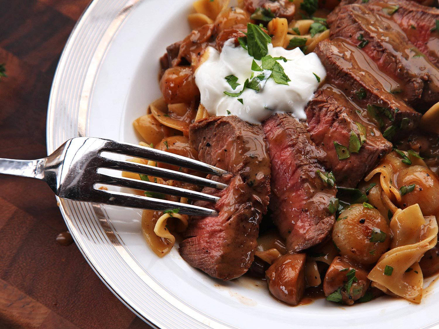 Delectable Medium-rare Beef Stroganoff Served With Farfalle Pasta Background