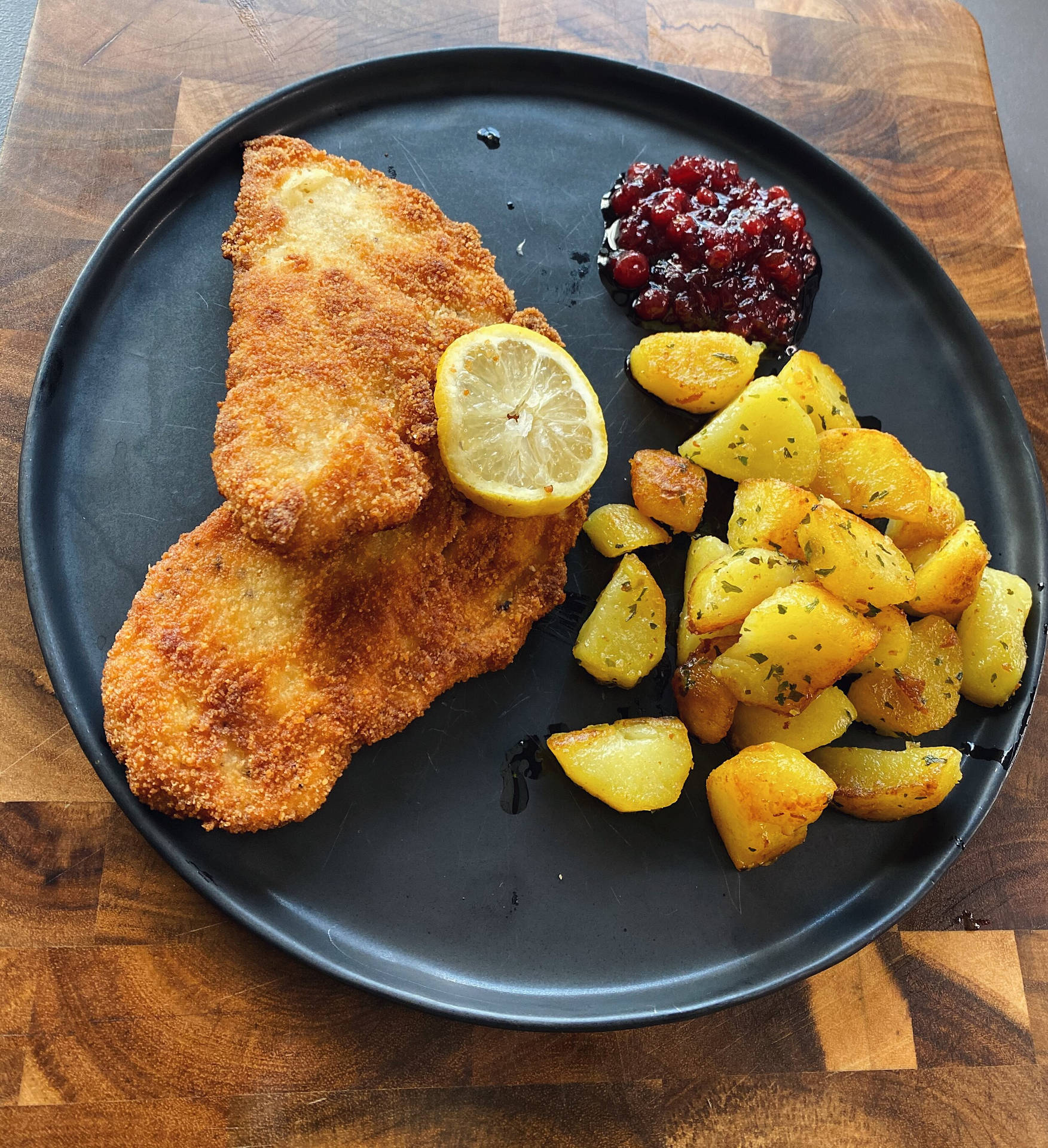 Delectable Wiener Schnitzel Served On A Black Platter Background