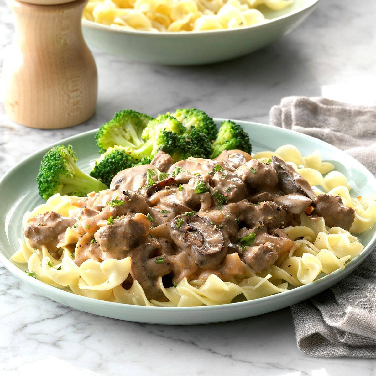 Delicious Beef Stroganoff Served Over Pasta With A Side Of Broccoli Background