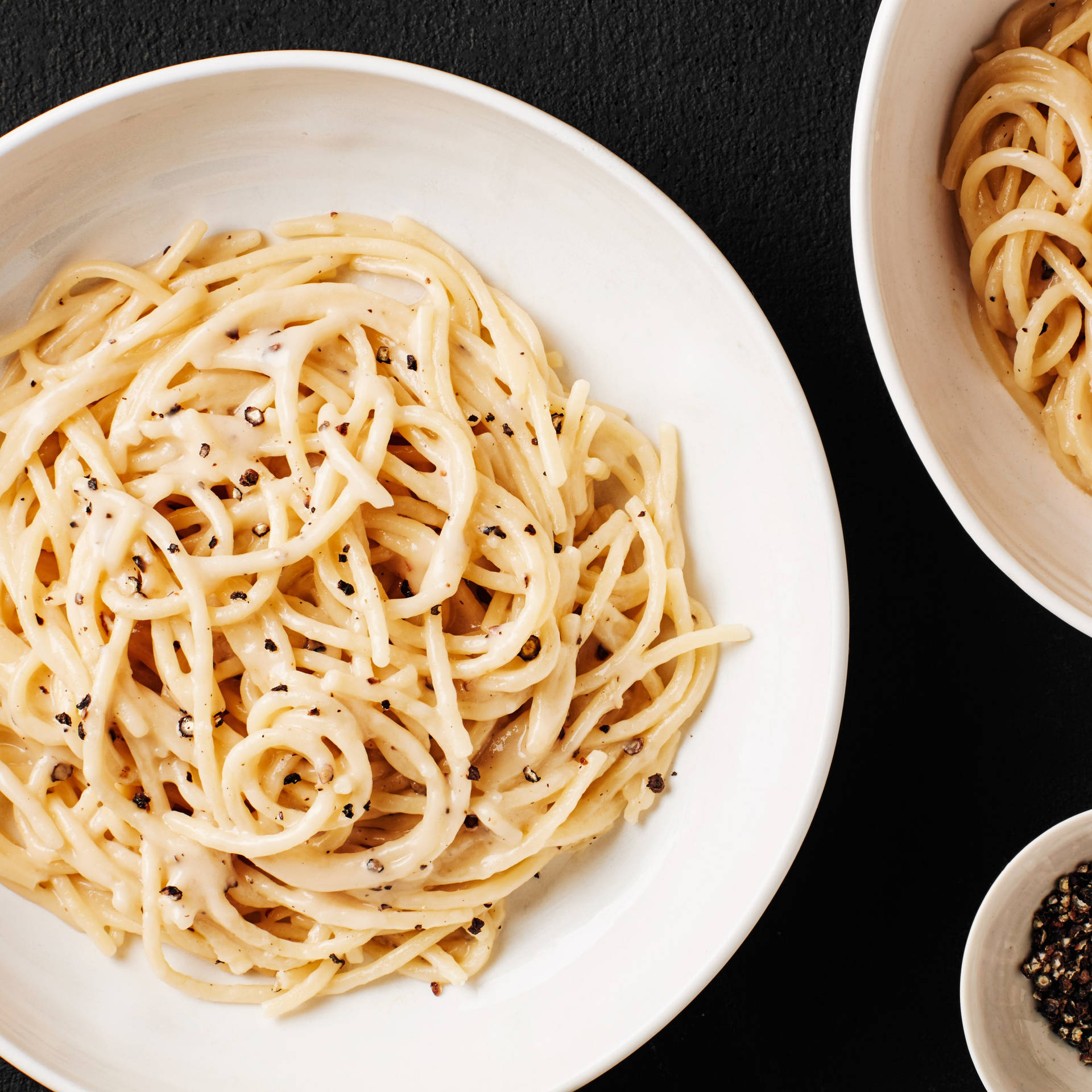 Delicious Bowl Of Cacio E Pepe With A Side Of Ground Pepper Background