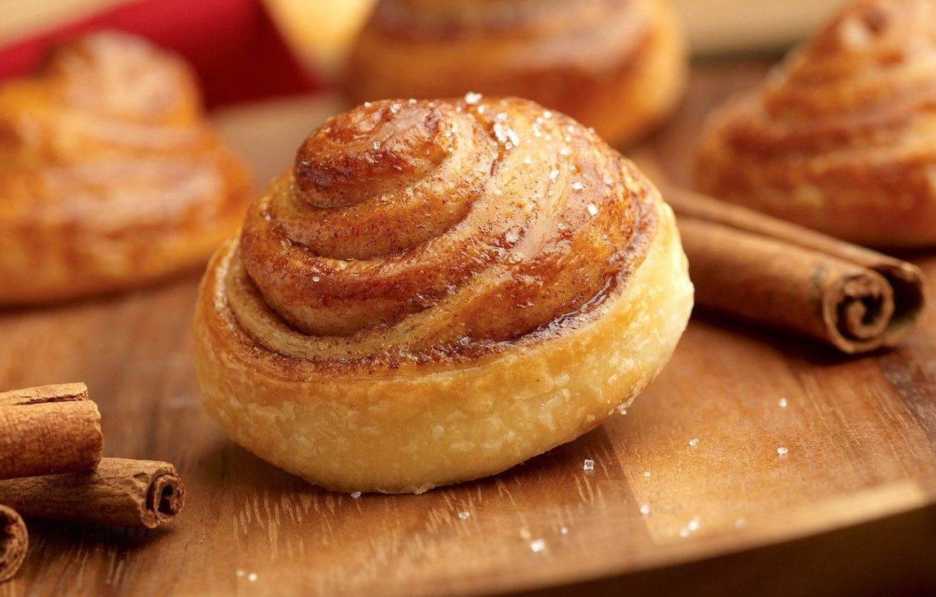 Delicious Cinnamon Bun Topped With Cinnamon Spice Background