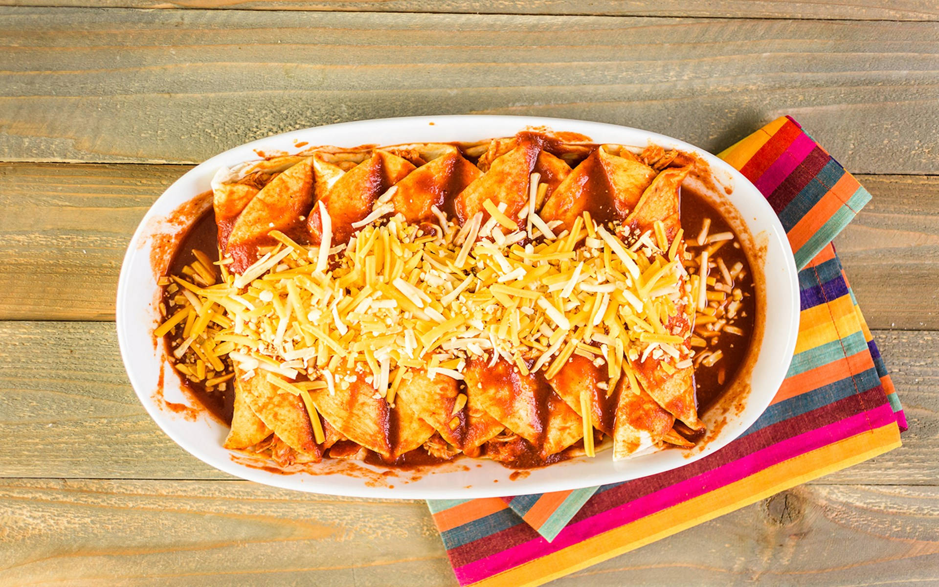 Delicious Enchilada Platter Topped With Cheddar Cheese. Background