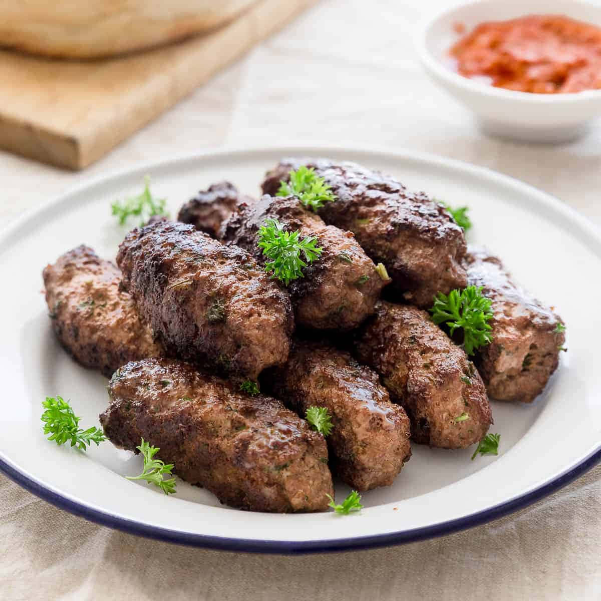 Delicious Fried Ćevapi Sausages Garnished With Fresh Herbs Background