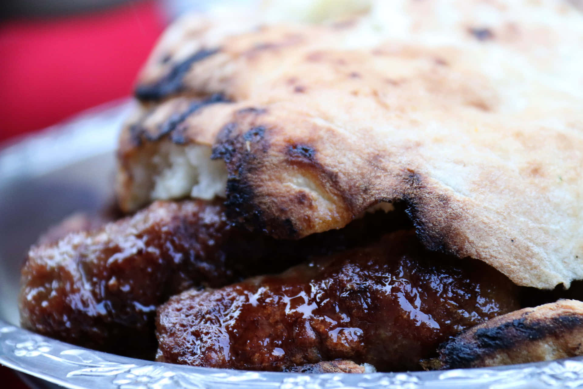 Delicious Platter Of Saucy Ćevapi Sausages In Pita Bread Background