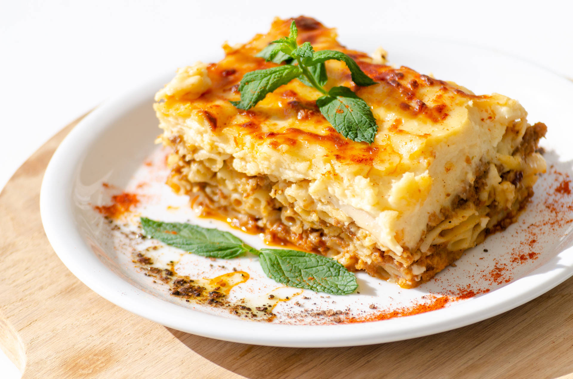 Delicious Slice Of Authentic Moussaka Garnished With Basil Background