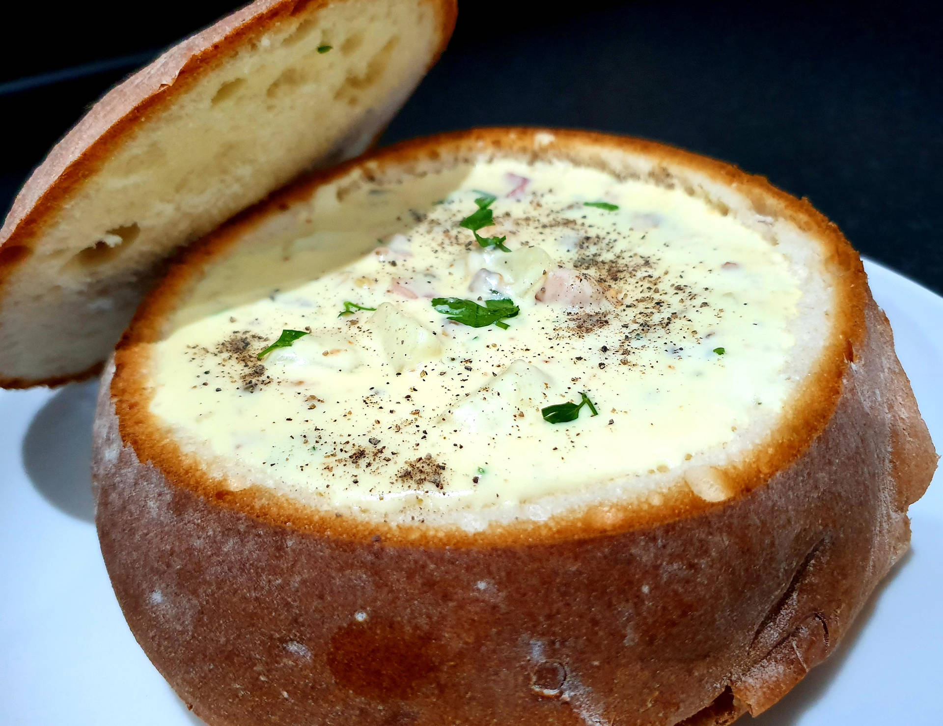 Delicious Sourdough Bread Bowl Filled With Creamy Chowder Background