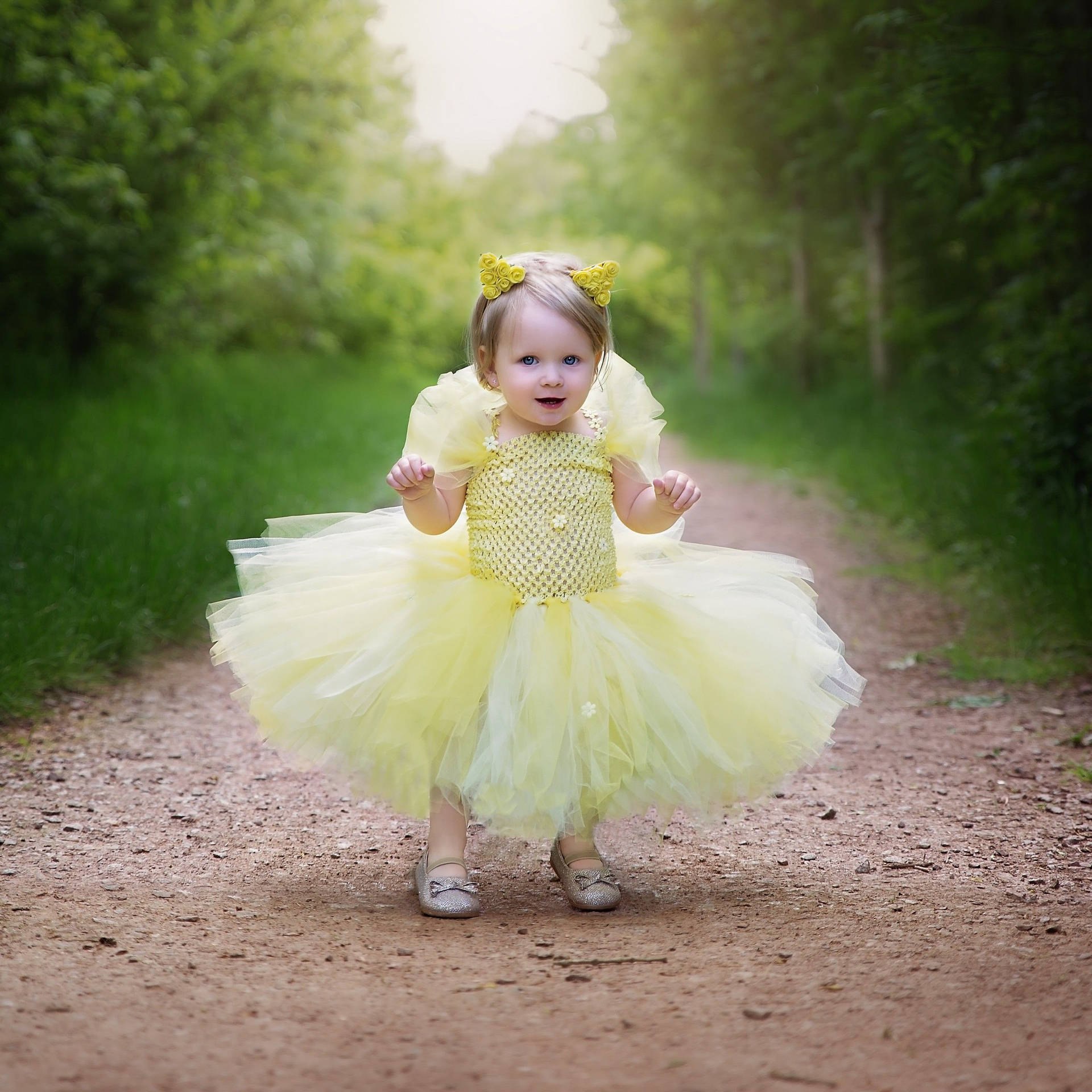 Delightful Baby Girl In Yellow Gown Background