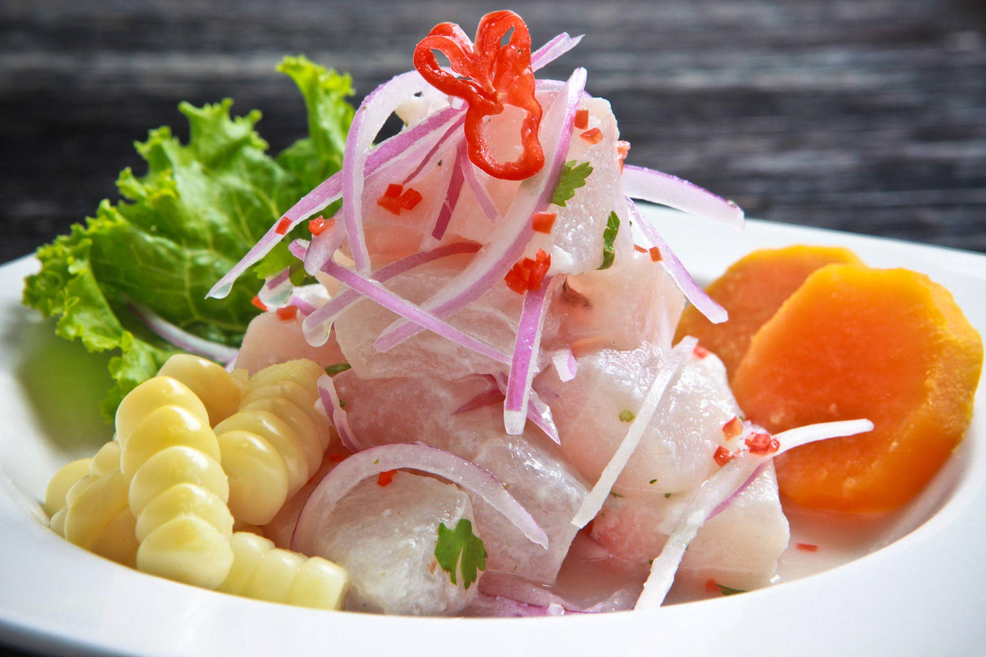 Delightful Ceviche Dish Served With Corn, Onions, And Sweet Potatoes Background