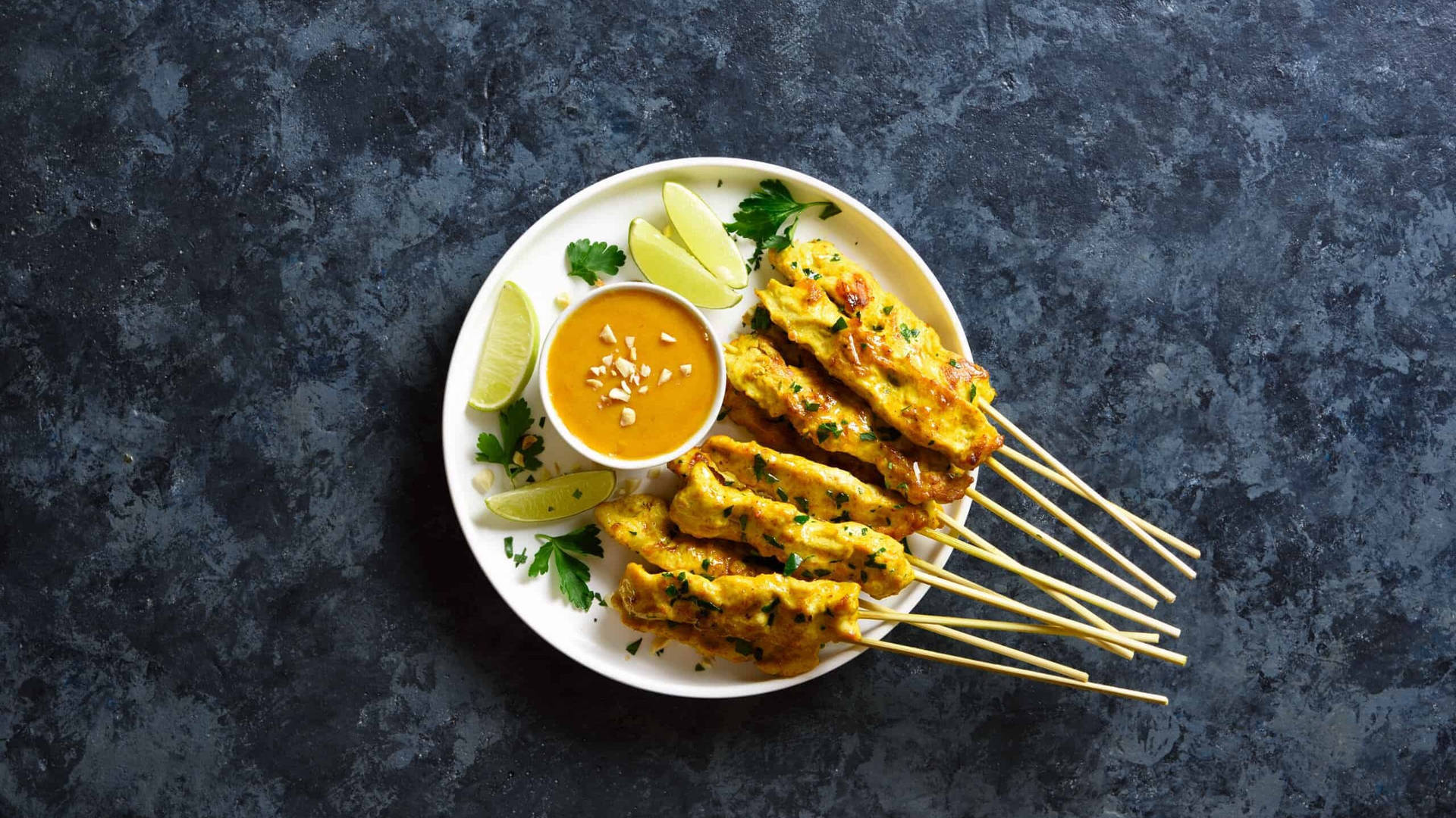 Delightful Chicken Satay With Savory Peanut Sauce And Fresh Cucumber Salad Background