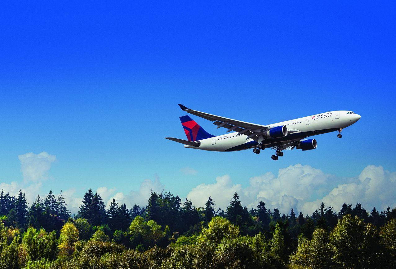 Delta Airlines Airplane Above Forest Trees Background