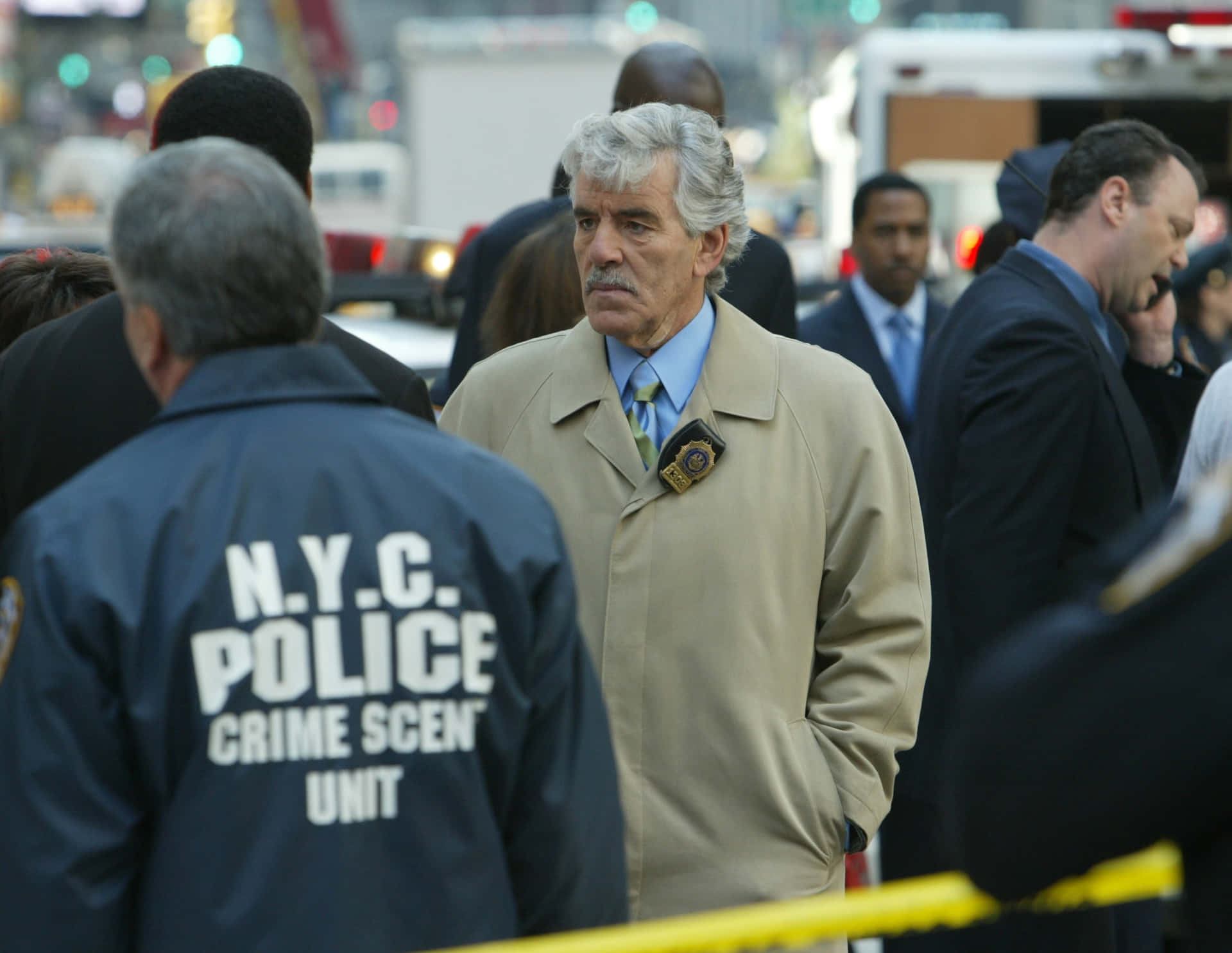 Dennis Farina Striking A Pose In A Suit And Tie Background