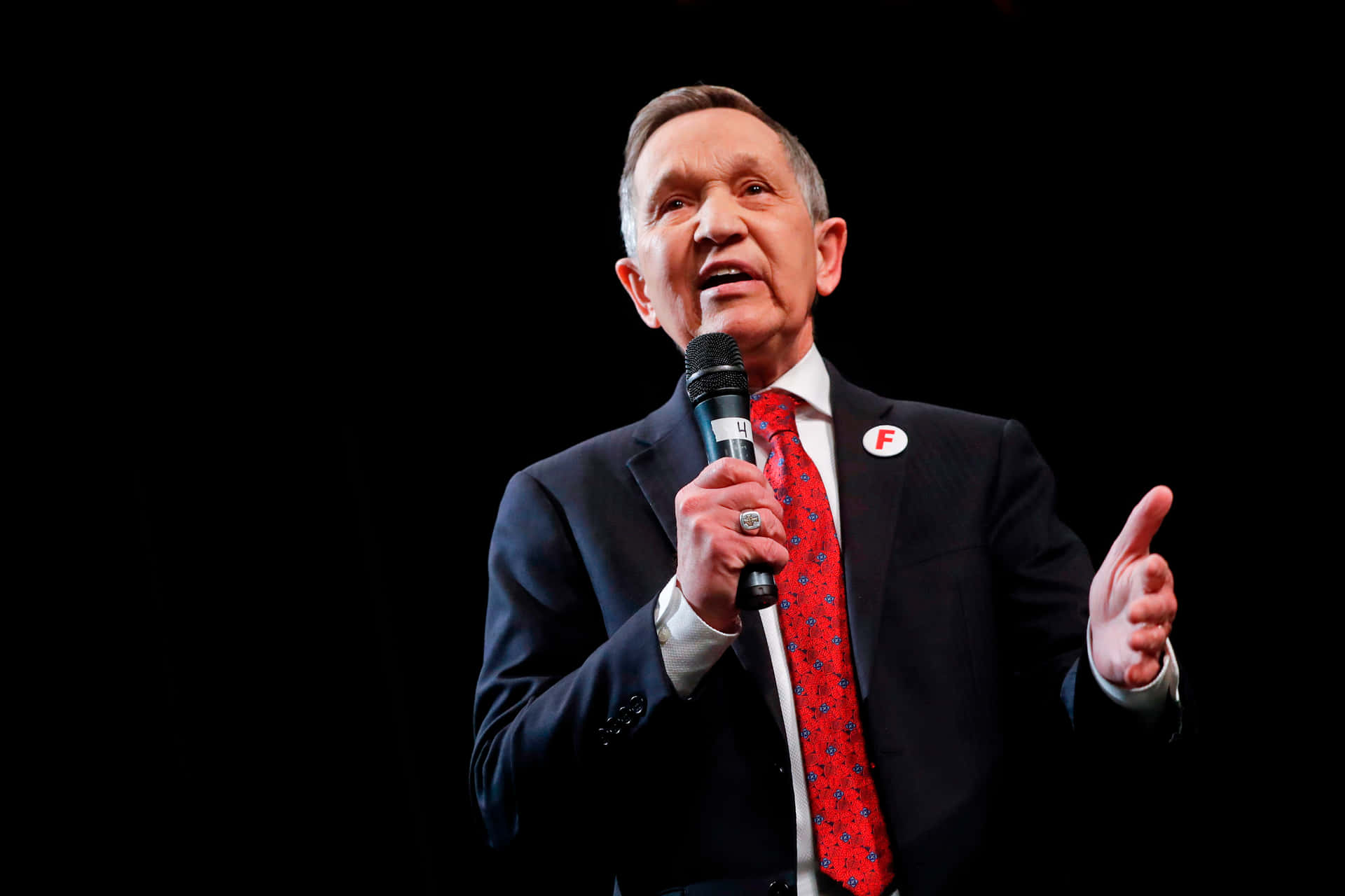 Dennis Kucinich With A Microphone Background