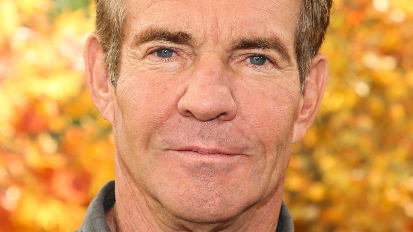Dennis Quaid Showing His Iconic Smirk Background