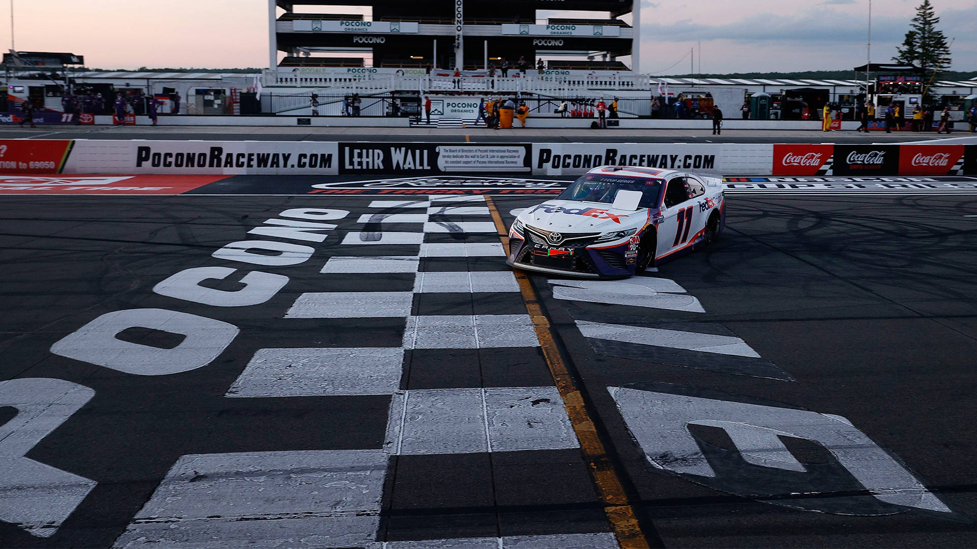 Denny Hamlin At The Finish Line Background