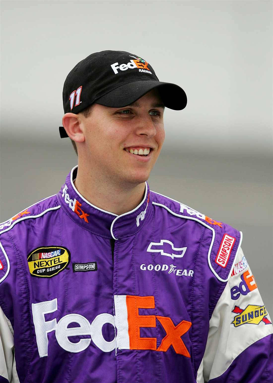 Denny Hamlin In Vibrant Purple Racing Suit Background