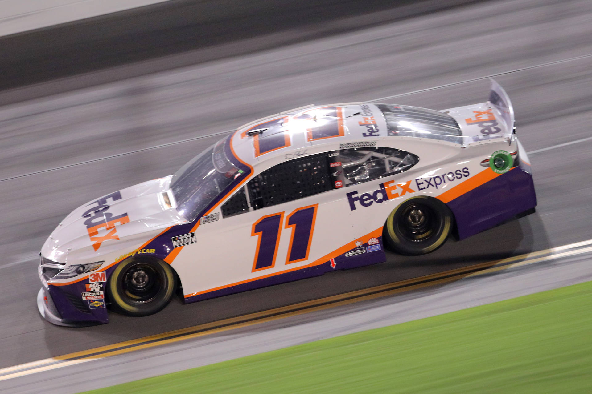 Denny Hamlin Speeding Down The Track Background