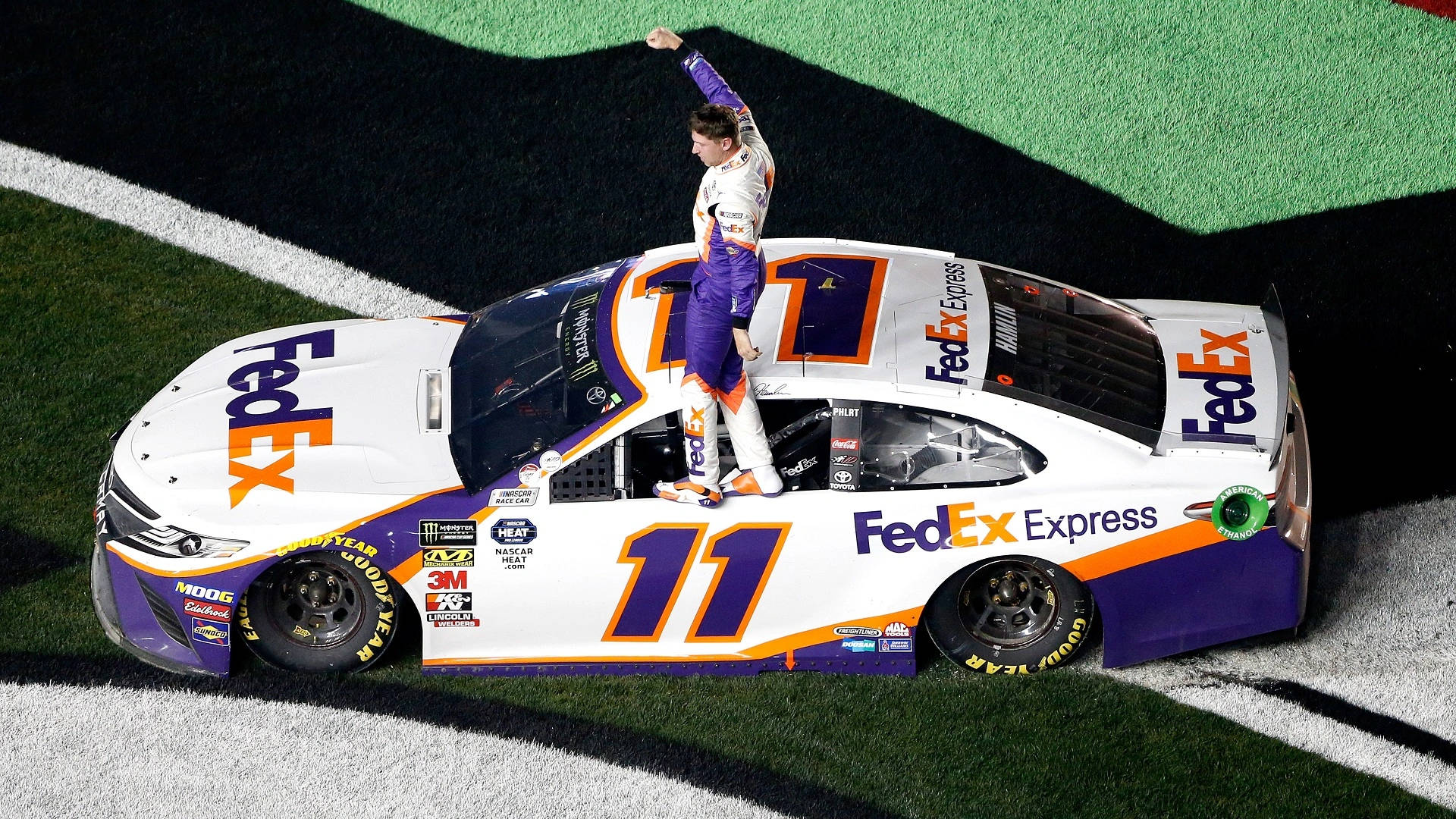 Denny Hamlin Standing On Car Door Background