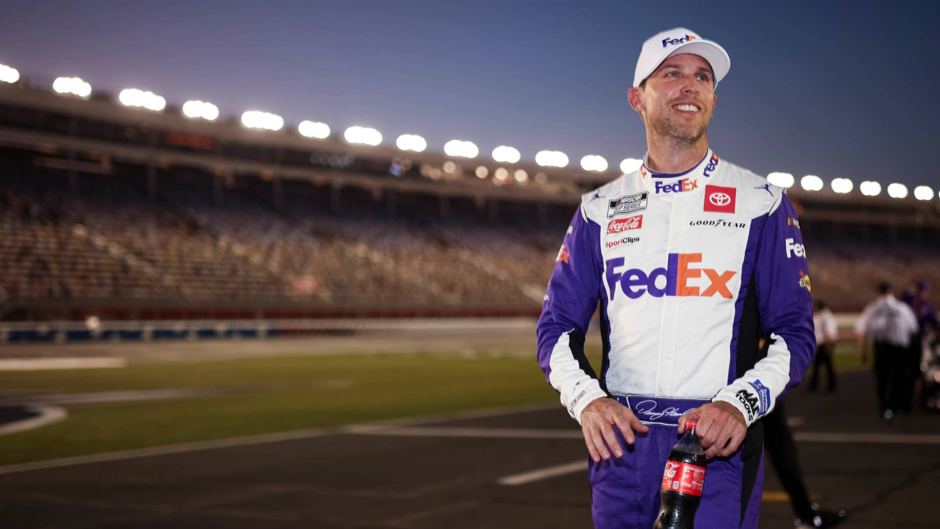 Denny Hamlin Wearing Fedex Cap And Suit Background