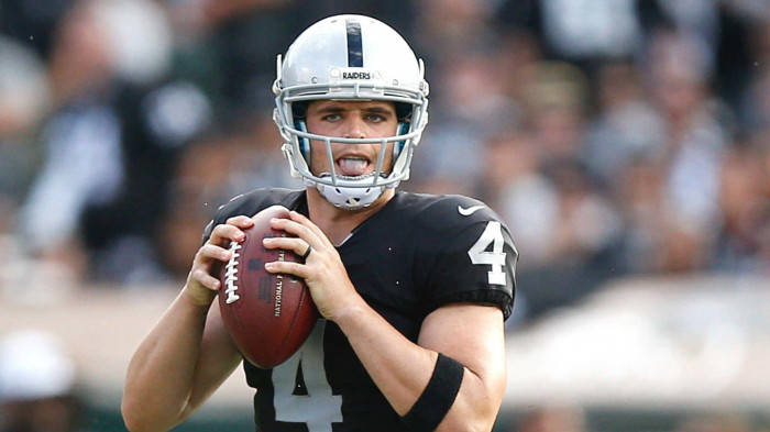 Derek Carr Holding Football With Two Hands Background
