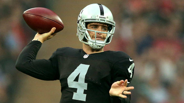 Derek Carr In Black Ready To Throw Ball Background