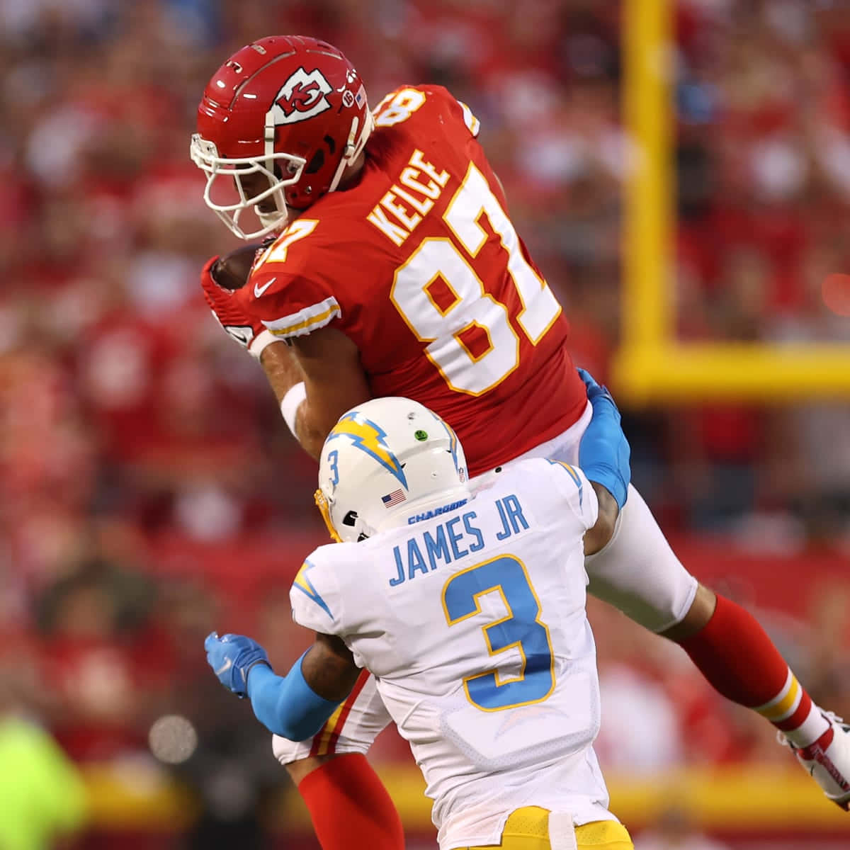 Derwin James Tackling Travis Kelce Football Player Background