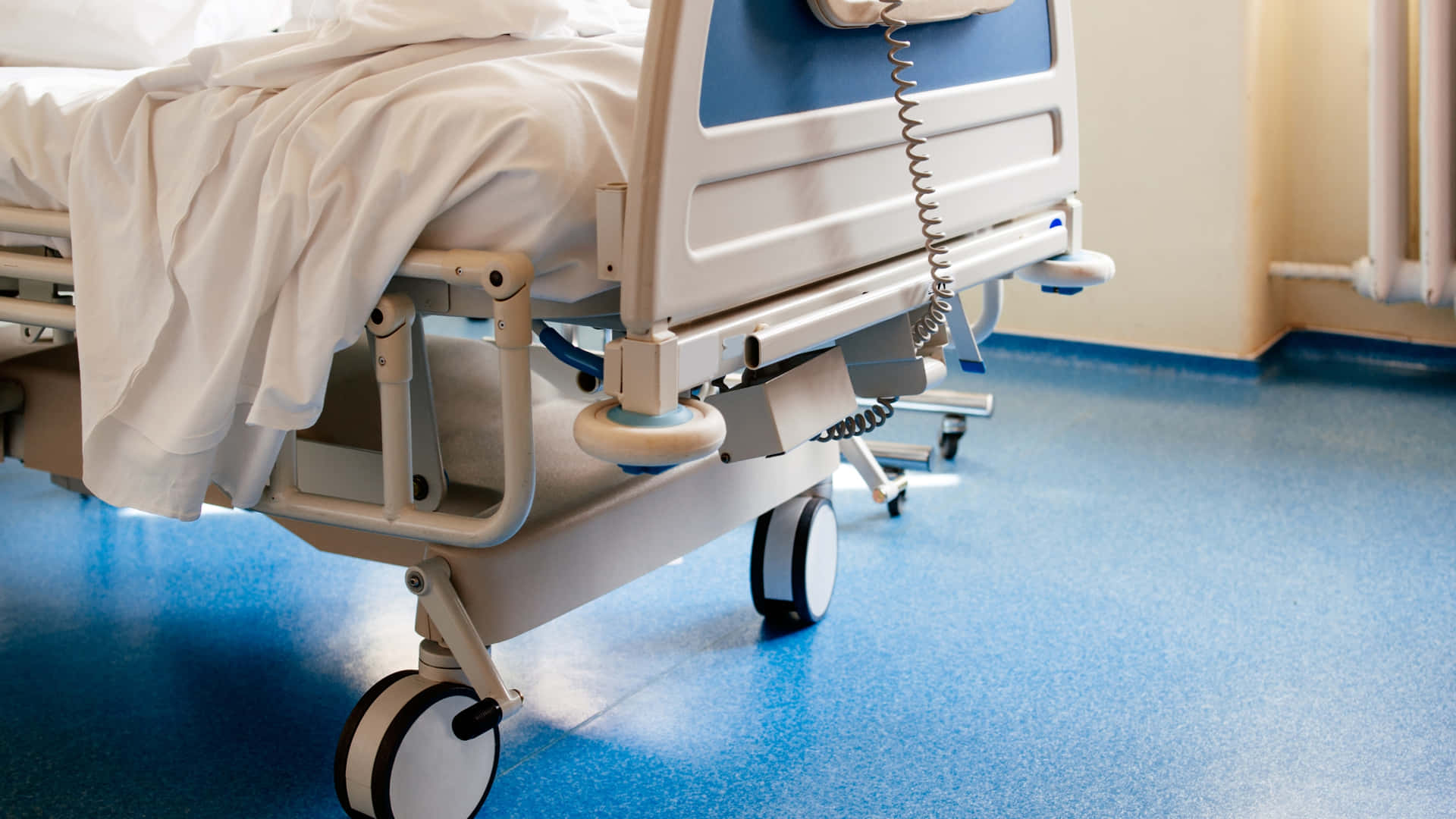 Detailed Close-up Of A Modern Hospital Bed With Wheels Background