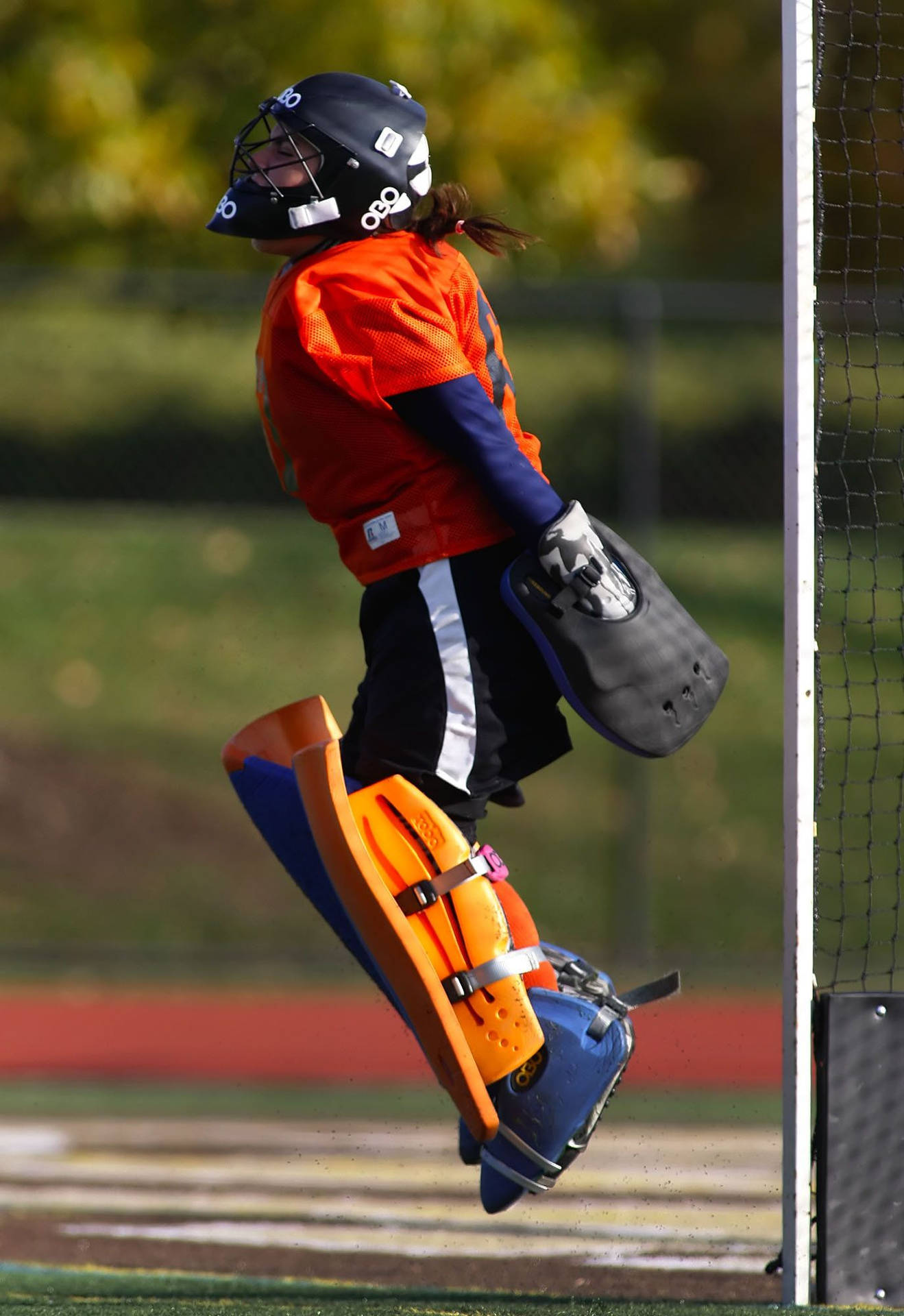 Determined Field Hockey Goalkeeper In Action Background
