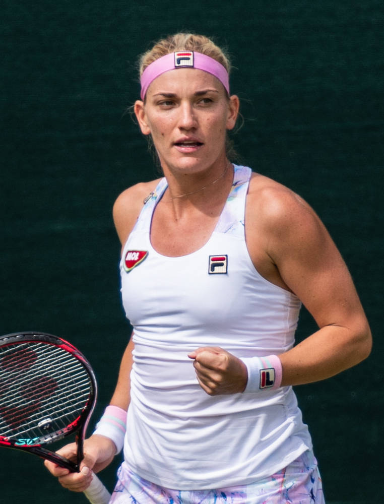 Determined Timea Babos Celebrating On The Tennis Court Background