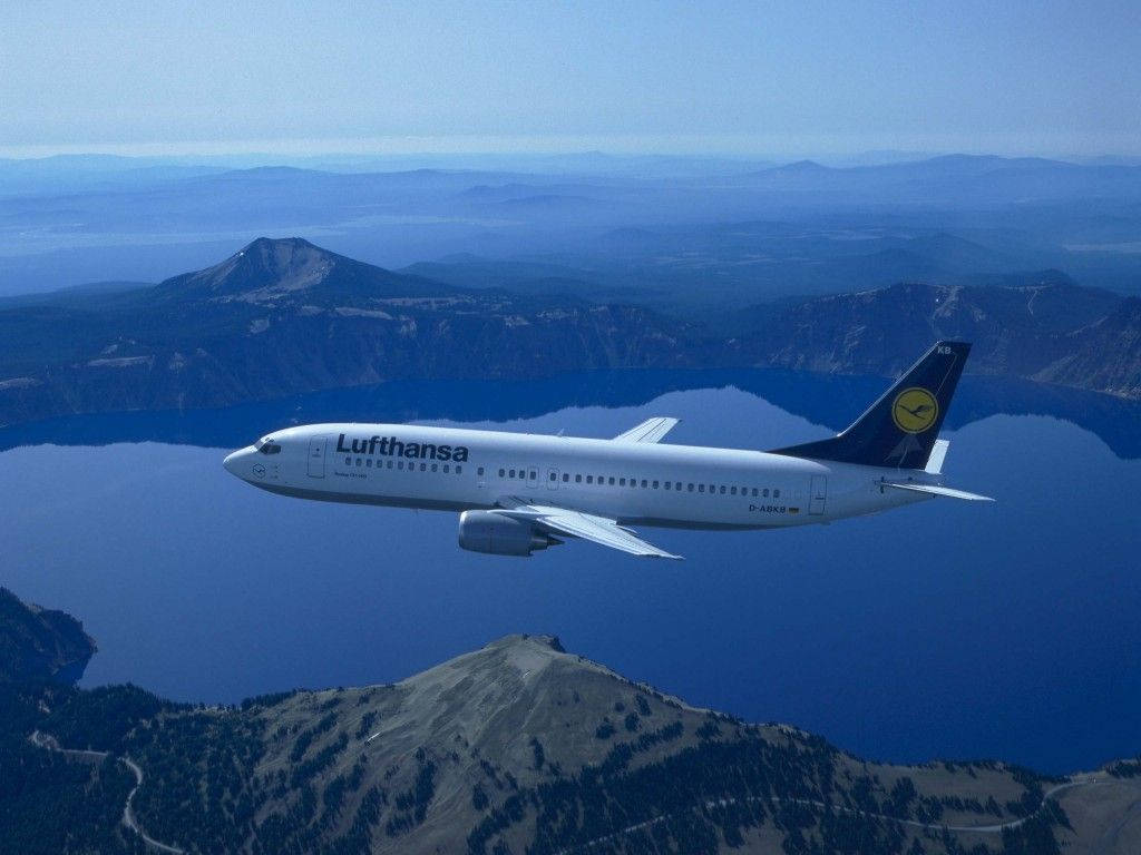 Deutsche Lufthansa Plane Above Mountains Background