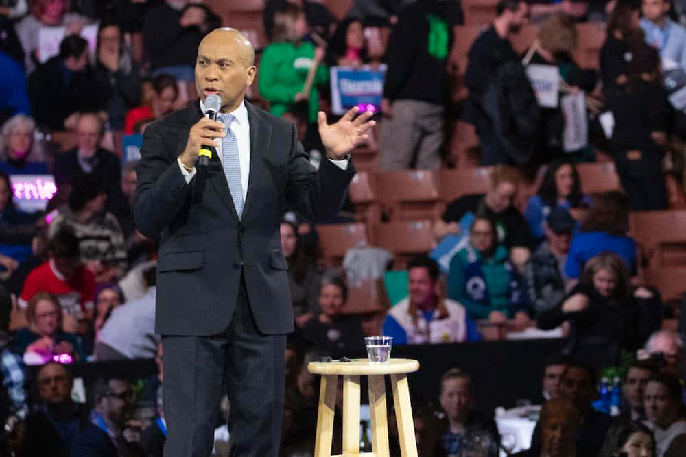 Deval Patrick Holding A Microphone Background