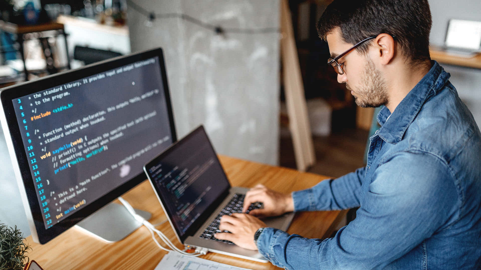 Developer Writing Code In Front Of A 1920x1080 Hd Monitor Background