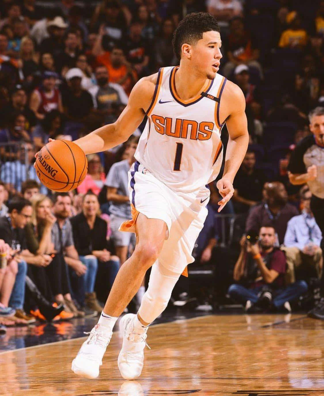 Devin Booker Glistening Mid-game In A Phoenix Suns Jersey. Background