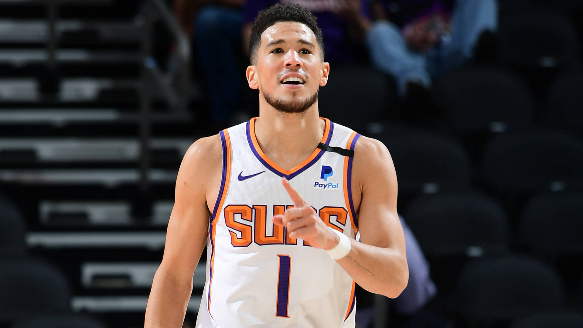 Devin Booker Smiling With Hand Raised Background