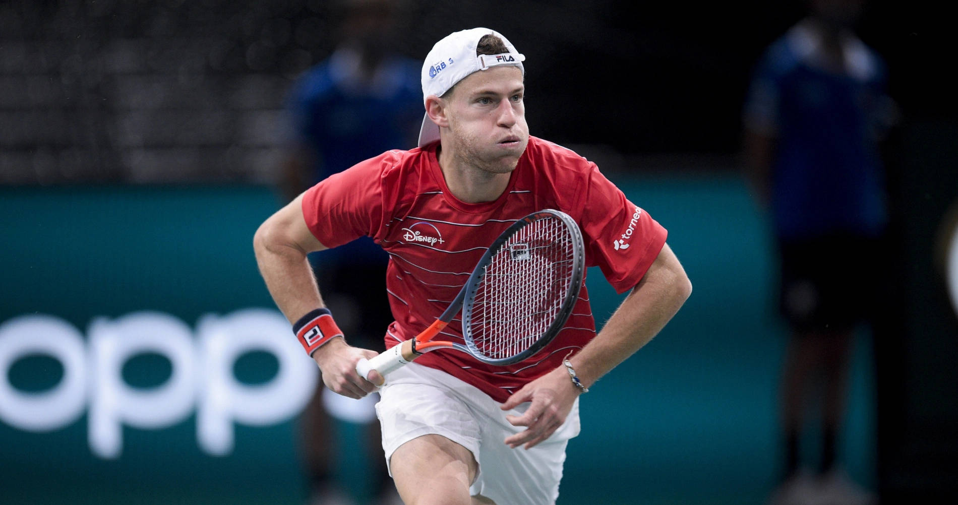 Diego Schwartzman Elegantly Charging For The Ball During A Tennis Match. Background