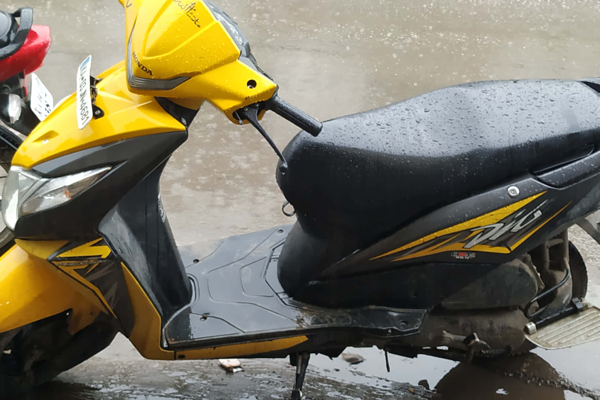 Dio Bike Drenched In Rain Water Background